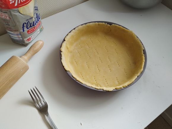 After kneading the dough, roll out the dough into a circle slightly larger than the diameter of the pie dish.
Butter the pie dish and transfer the dough to it.
If the dough extends beyond the edges, don't trim it yet.
Prick the dough with a fork.