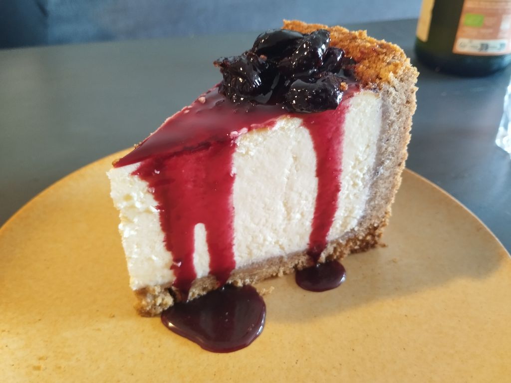 A slice of New York-style cheesecake with a graham crust and a cream cheese filling