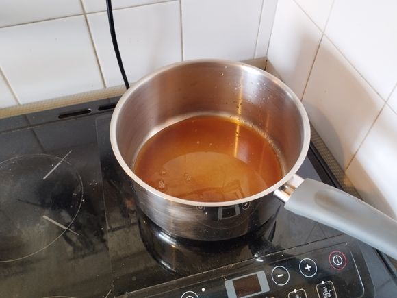 While the pie crust is baking, let's prepare the filling.
Place the sugar (200 g) and water (60 g) in a saucepan and turn on the heat until it forms a dark caramel sauce.