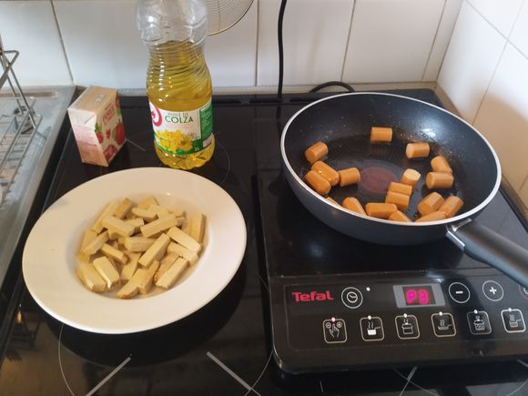 Cut the three sausages into roughly 2 cm long pieces. Cut the tofu into allumettes (thin short strips). In a pan, add some oil (e.g: canola oil) and start with the sausages for a couple minutes.