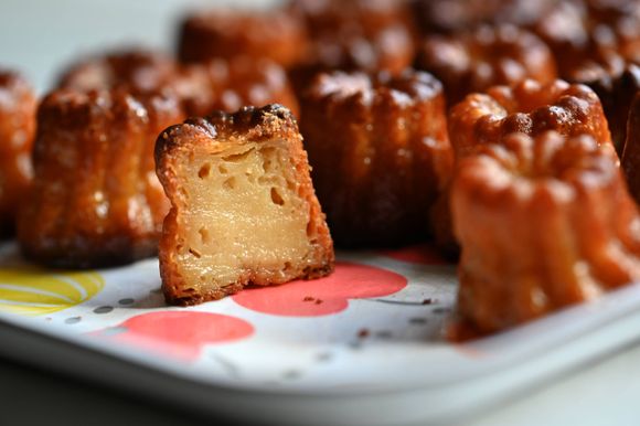 The inside of a Canelé, showing the contrast between the crusty outside and the custardy inside