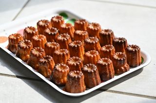 A tray of Canelés, showing their characteristic shape and golden color