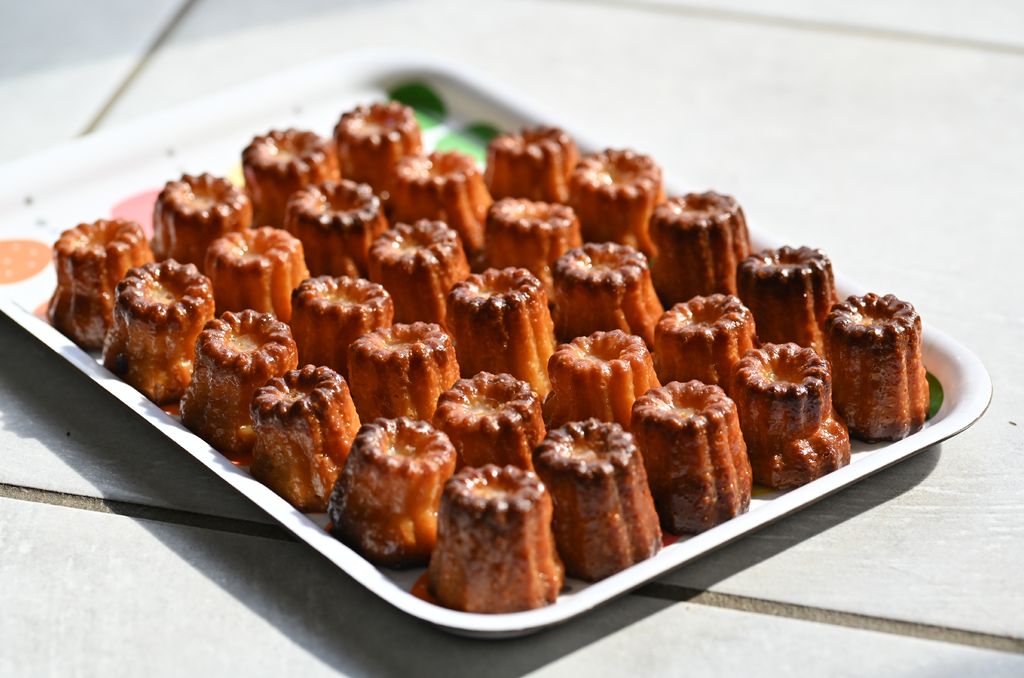 A tray of Canelés, showing their characteristic shape and golden color